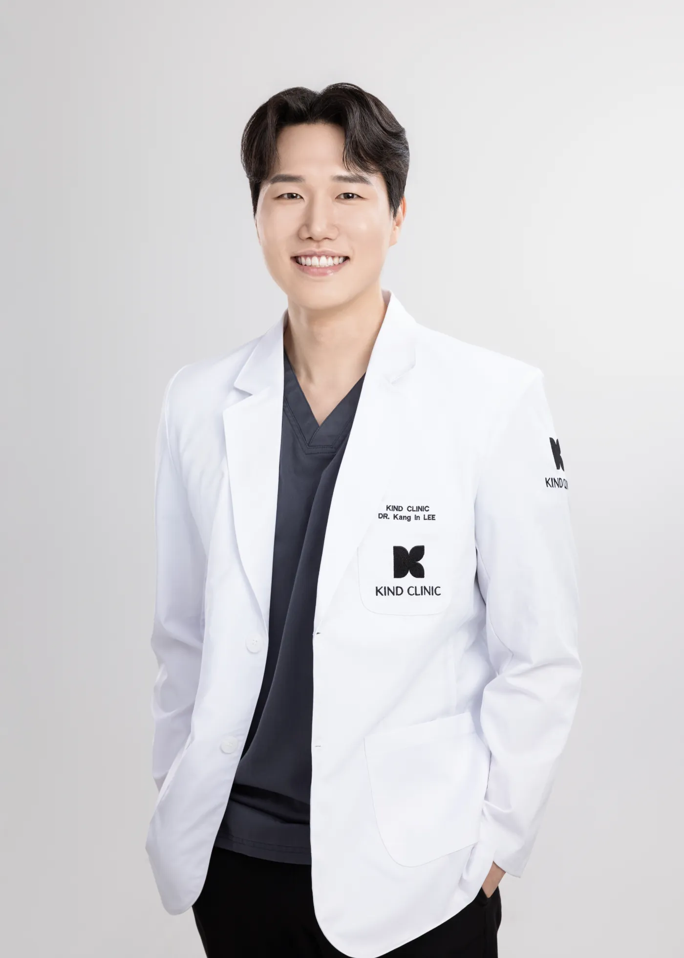 Dr. Lee Kang In, representative director of Kind Global Clinic Myeongdong, in a Kind Clinic white coat over gray scrubs.